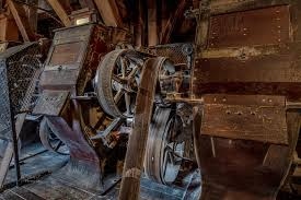 Close-up of a Goldie and McCulloch roller mill with cast-iron flywheel and belt drive